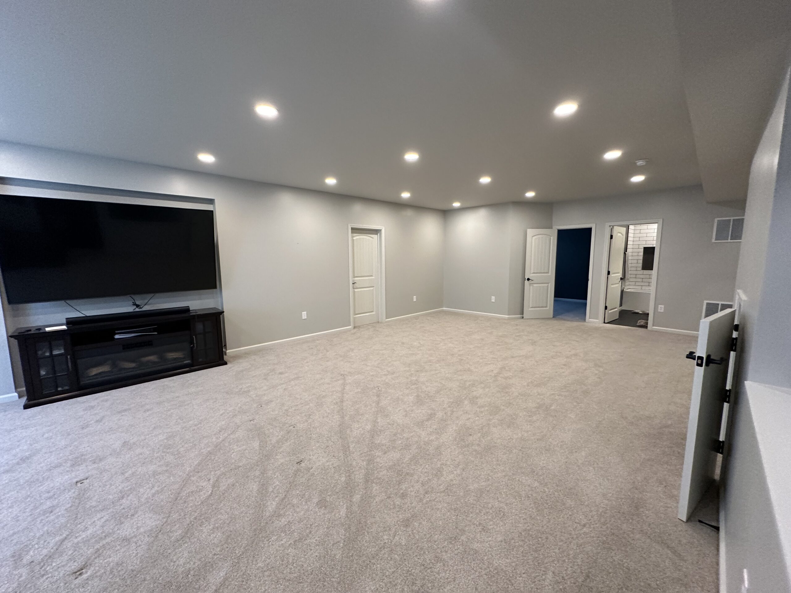 Finished basement with theater-lounge seating and a small home-gym area, designed for winter comfort.